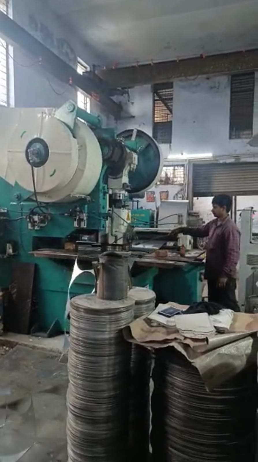 Zig-zag stamping press blanking stainless steel circles, with finished circles stacked below