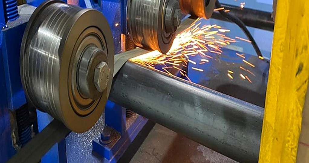 Stainless steel pipe being welded and scarfed on the ERW tube mill